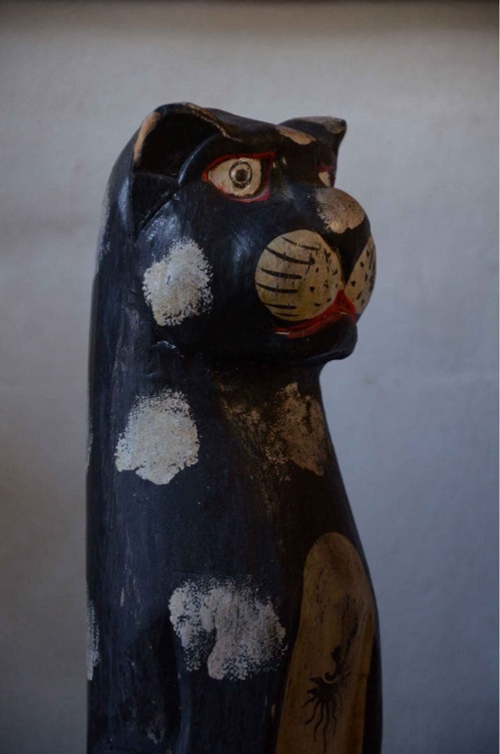 遠くを見る木彫りの猫